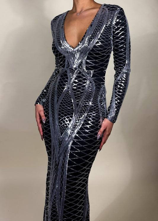 Red carpet dress
Gala night outfit
New Year's Eve gown
Black tie event dress
Formal wedding guest dress Fall and winter formal dress
Holiday party outfit
Spring gala fashion
Timeless luxury evening wear
Deep V-neck sequin dress
Geometric pattern evening gown
Floor-length bodycon gown
Metallic shimmer long sleeve dress
High-fashion event wear
Glamorous sequin gown
Luxury evening dress
Silver embellished maxi dress
Bodycon long sleeve gown
Black and silver statement dress