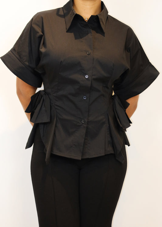 Workwear, Business casual, Office chic, Evening dinner, Smart casual, Formal event, Executive style, Professional attire, Stylish everyday wear, Button-up blouse, Short-sleeve collared shirt, Cinched waist detail, Side bow-tie accents, Asymmetrical hem, Structured silhouette, Tailored fit, Modern minimalist, Statement side ruffles, 
Black button-up blouse, Statement work blouse, Designer-inspired structured shirt, Elegant office top, Short-sleeve dress shirt for women, Unique business casual top, Asymmetric