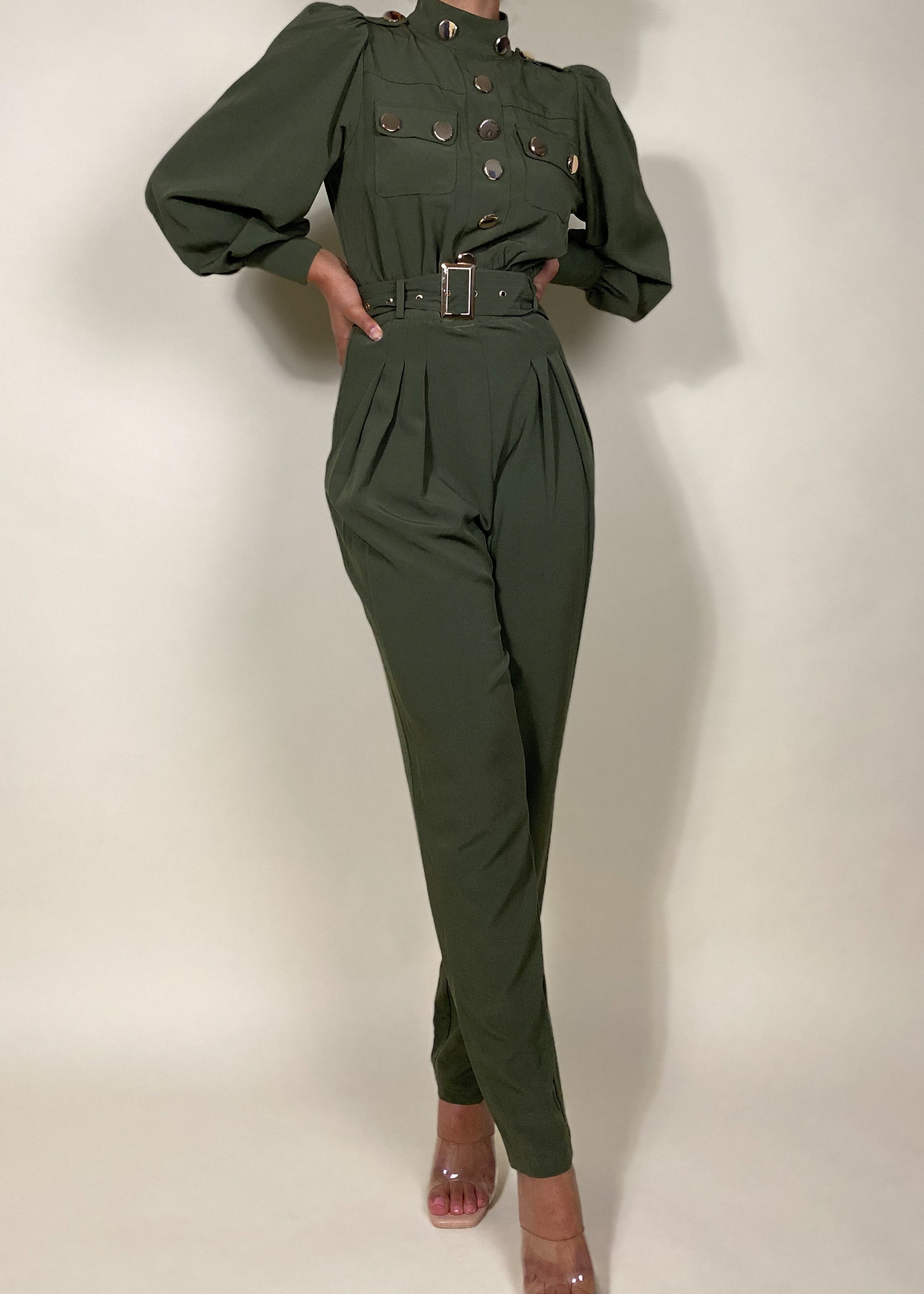 Chic workwear jumpsuit
Stylish office outfit
Smart-casual power dressing
Elegant dinner date fashion
Sophisticated fall/winter outfit
High-fashion street style
Modern military fashion
Professional yet trendy look
Stylish formal event attire
Statement jumpsuit for any occasion
Military-inspired jumpsuit
Gold button-detail jumpsuit
High-waisted structured jumpsuit
Utility fashion trend
Long sleeve jumpsuit with epaulets
Tailored jumpsuit with belted waist
Fashion-forward cargo jumpsuit
Pleated trouser
