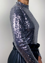 Night-out sequin blouse
Party wear metallic top
Holiday celebration outfit
New Year's Eve statement top
Clubbing fashion must-have
Special occasion shimmer top
Silver high-neck sequin top
Fully embellished disco blouse
Glittery long-sleeve top
Luxury sparkle statement piece
Fitted metallic fashion blouse
Shiny high-gloss party top
Glamorous eveningwear fashion
Bold statement night-out look
High-fashion sequin trend
Luxe dazzling fashion aesthetic
Vintage disco-inspired top
Chic and trendy metallic wear